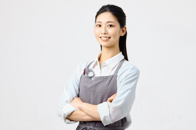 エプロン姿で腕を組む女性
